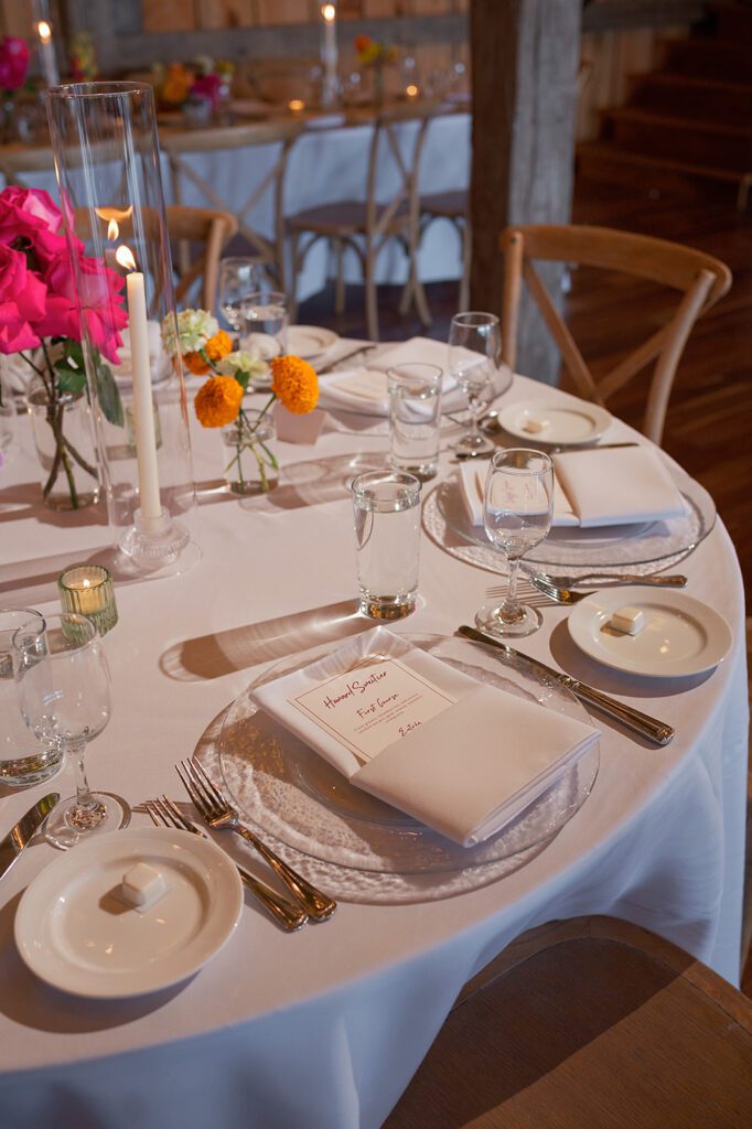 Close-up of a wedding place setting with florals and menu at a Noverr Farms wedding reception in Traverse City, Michigan.