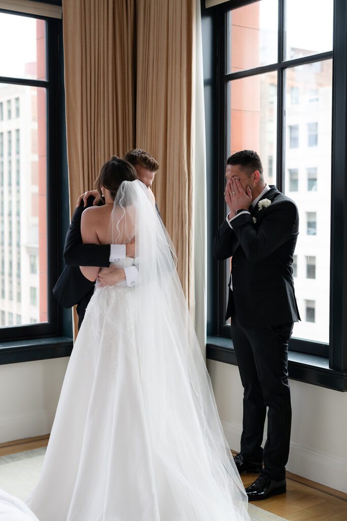 Bride sharing an emotional first look with her brothers at Shinola Hotel in Detroit, Michigan.