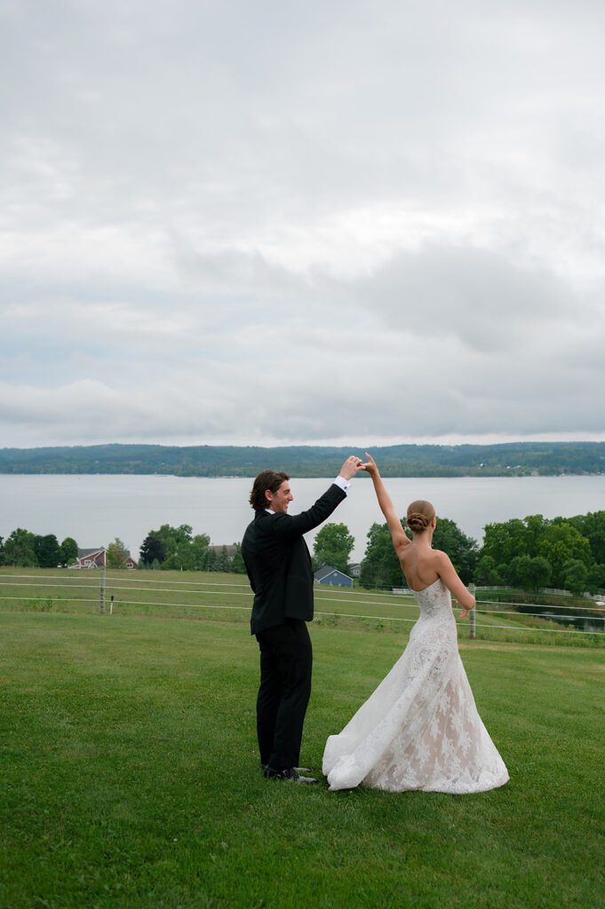 Bride and groom twirling together during portraits at Noverr Farms in Traverse City, Michigan.