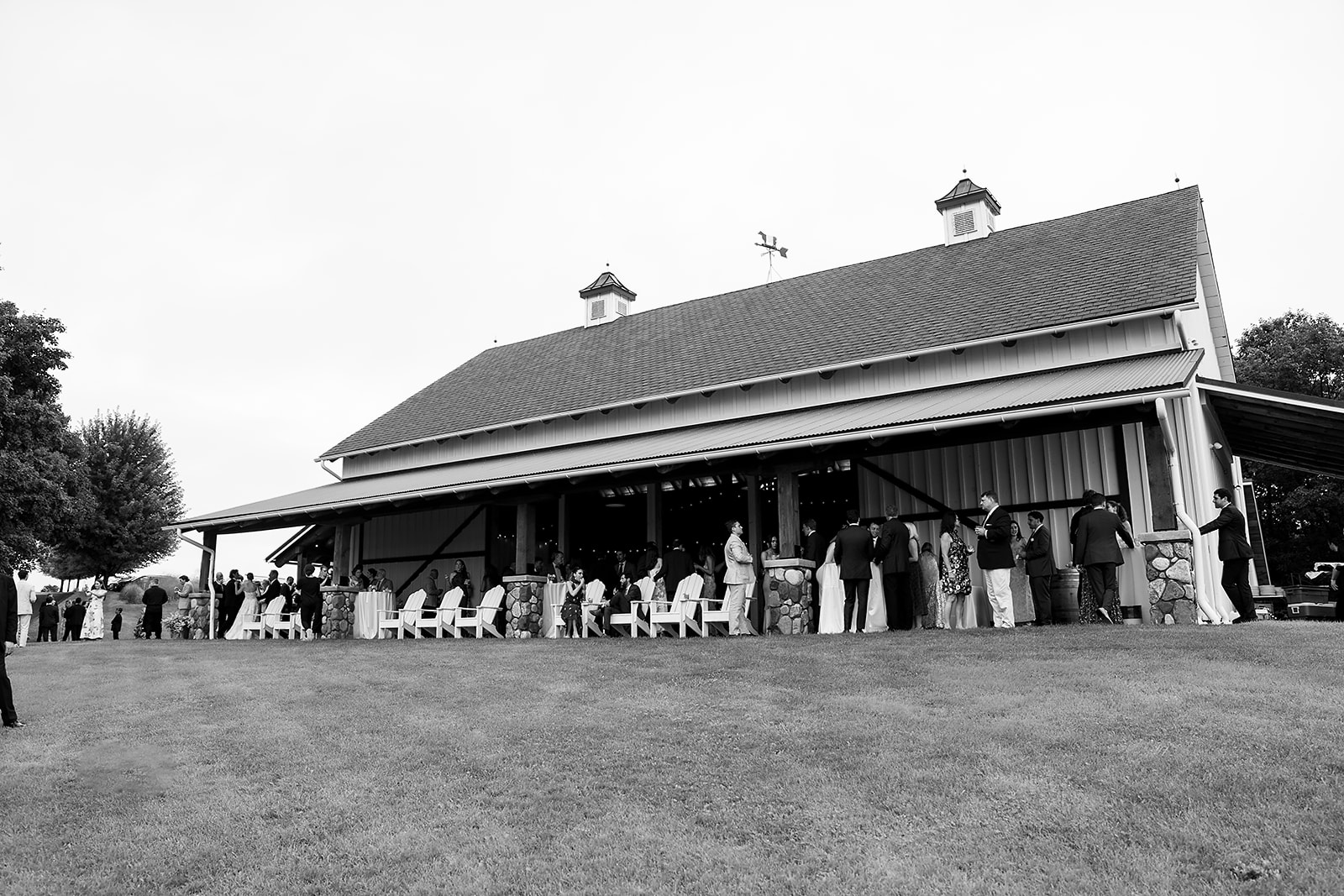 Guests mingling outside the barn during cocktail hour at Noverr Farms wedding venue in Traverse City, Michigan.