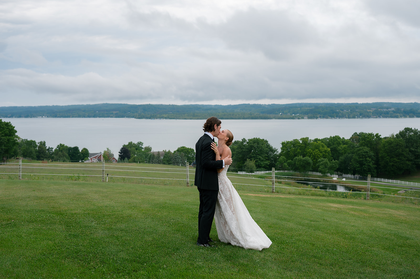 Bride and groom sharing a kiss overlooking Lake Leelanau at Noverr Farms in Traverse City, Michigan.