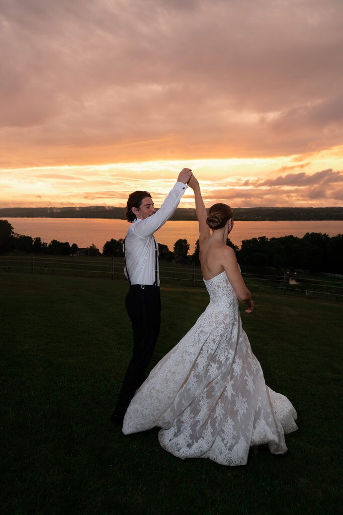 Groom twirling his bride during sunset at Noverr Farms in Traverse City, Michigan.