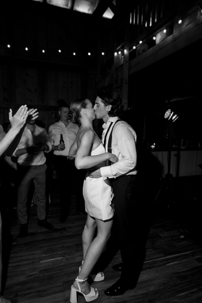 Bride and groom sharing a kiss during late-night dancing at their Traverse City wedding.
