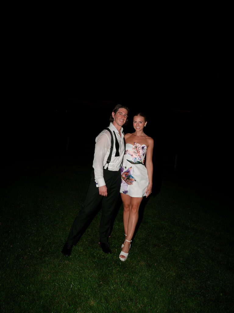 Bride and groom posing together in during their late-night reception at Noverr Farms.