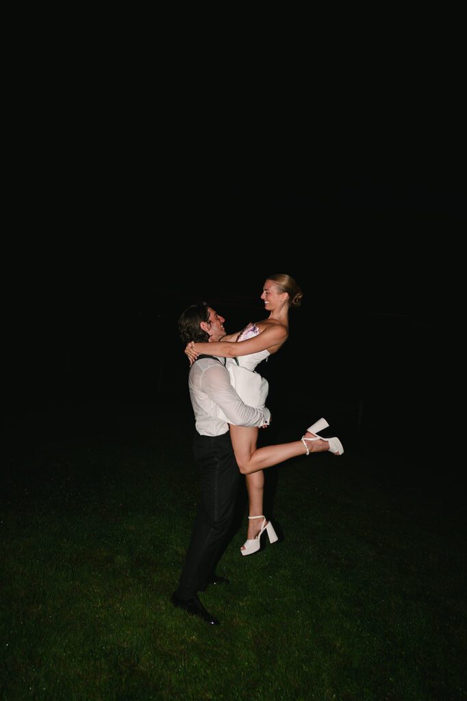 Bride and groom posing together in during their late-night reception at Noverr Farms.