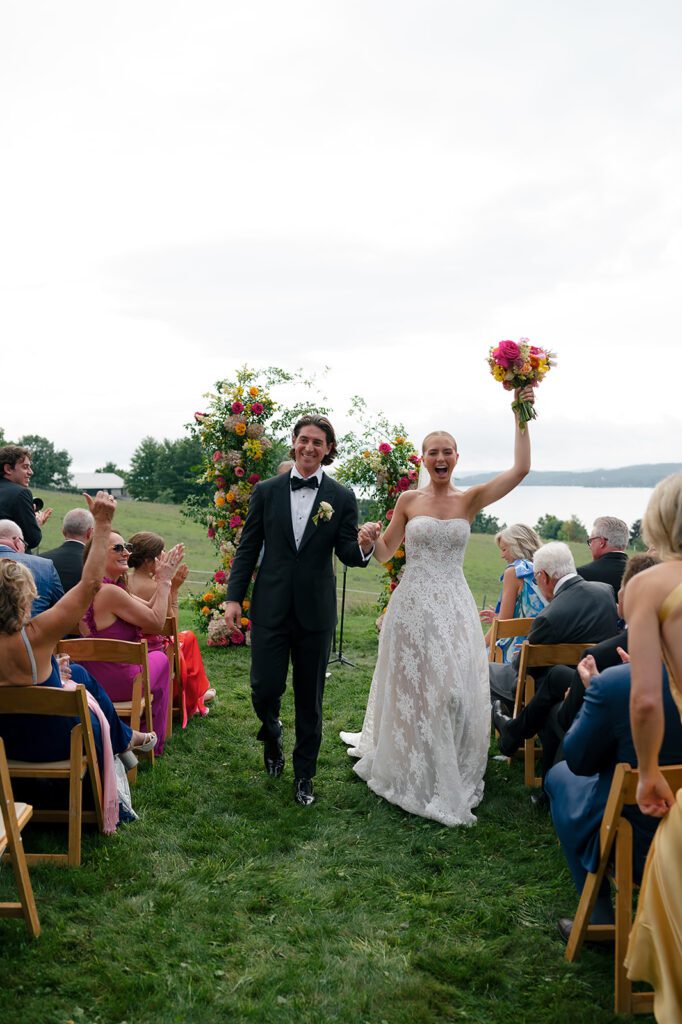 Newlyweds walk back down the aisle after their ceremony at Noverr Farms in Traverse City, Michigan.